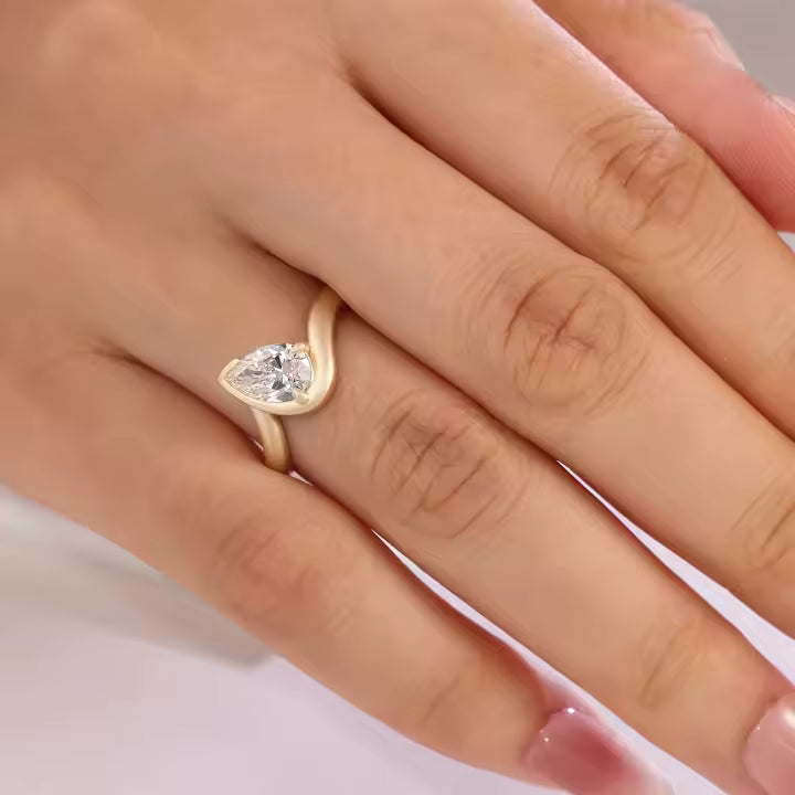 Pear cut lab diamond ring in brushed yellow gold with bypass setting